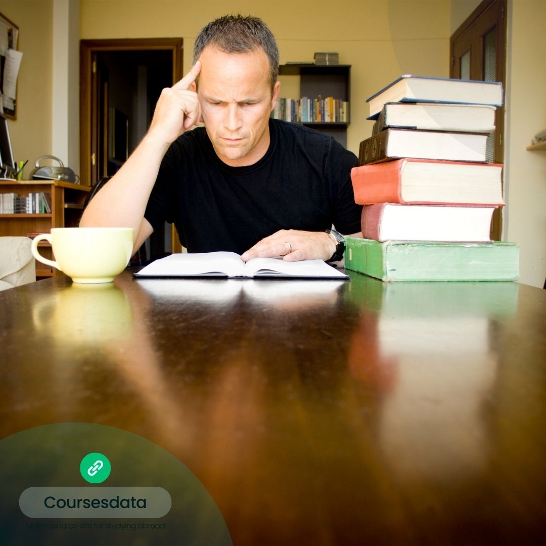 Man studying with stacked books.