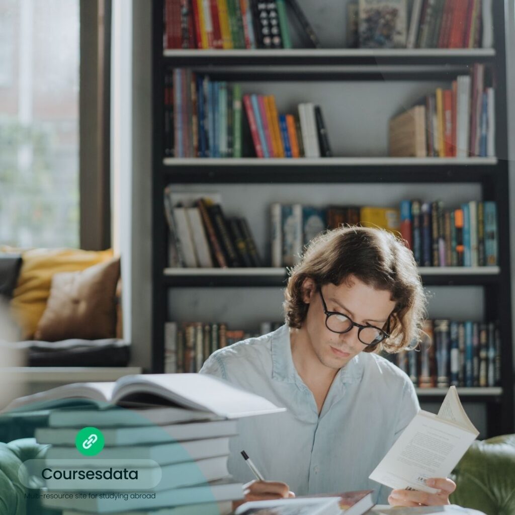 Man studying amidst bookshelves.