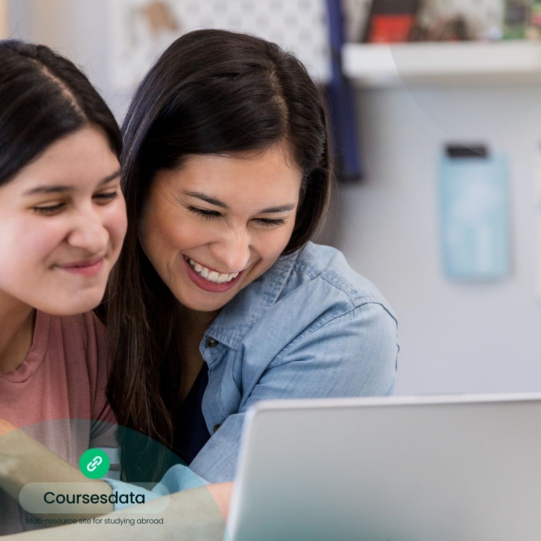Two women smiling at laptop.