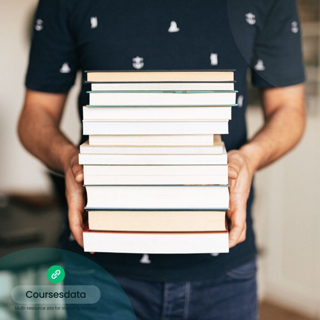 Person holding a stack of books.