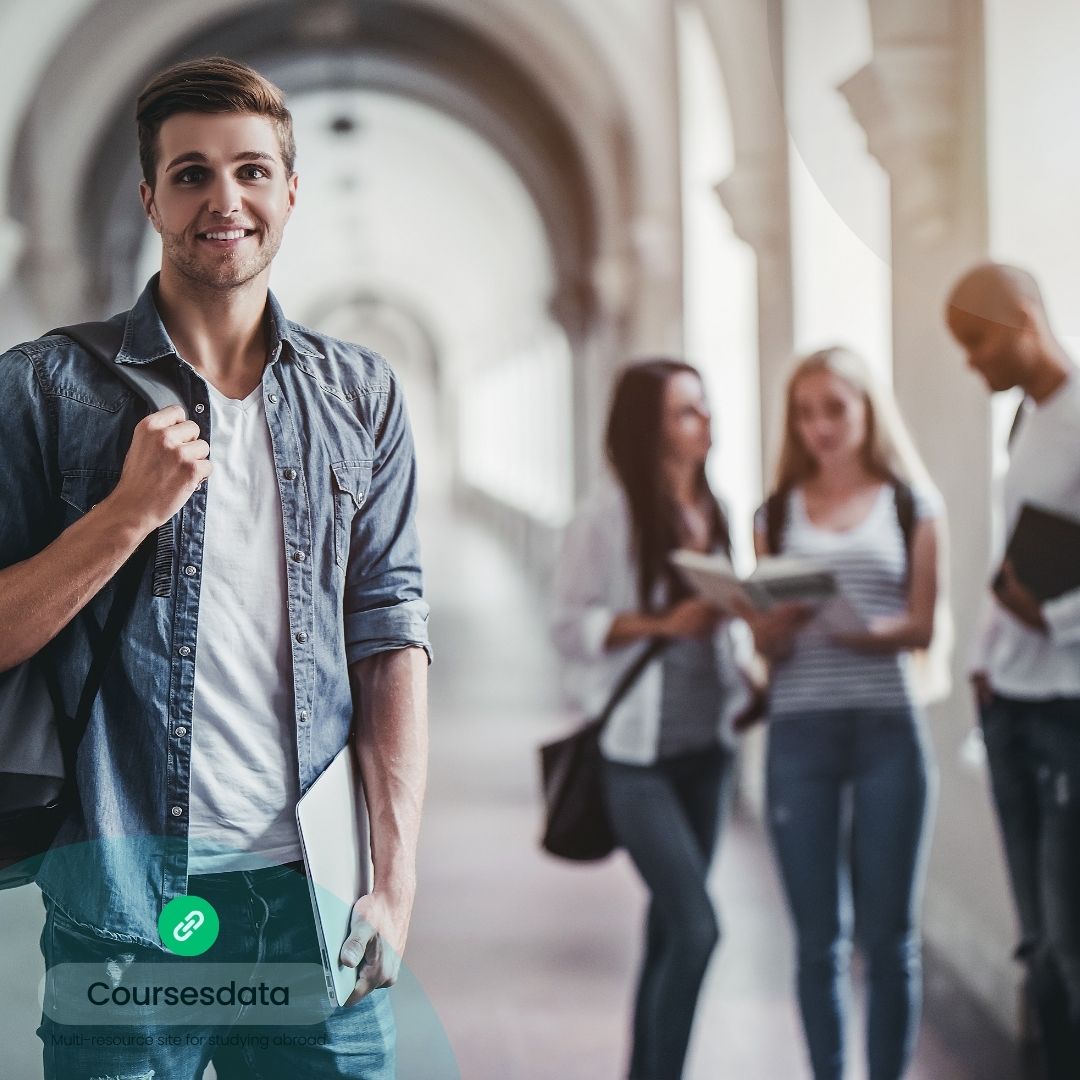 Smiling student in university hallway.