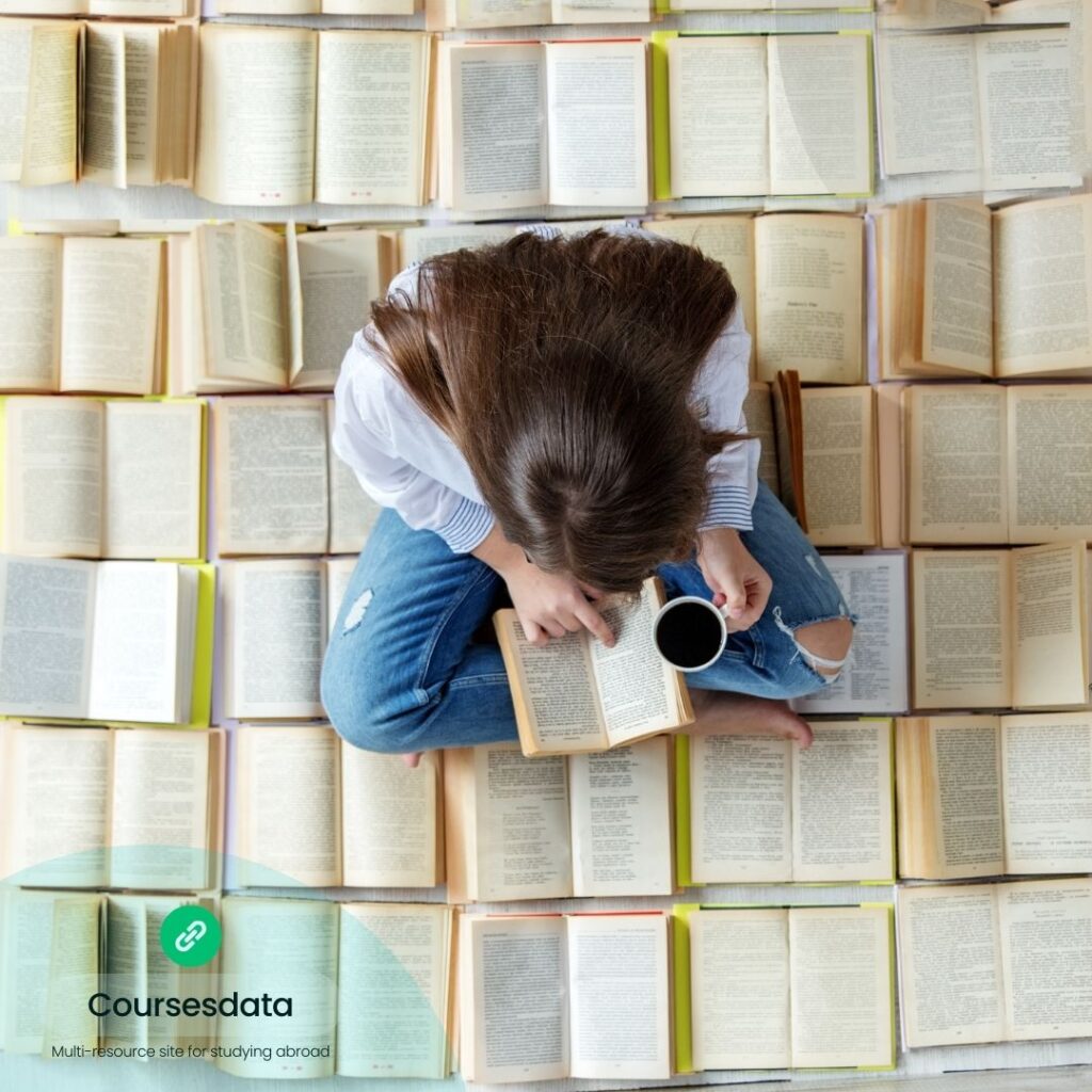 Person reading surrounded by books.