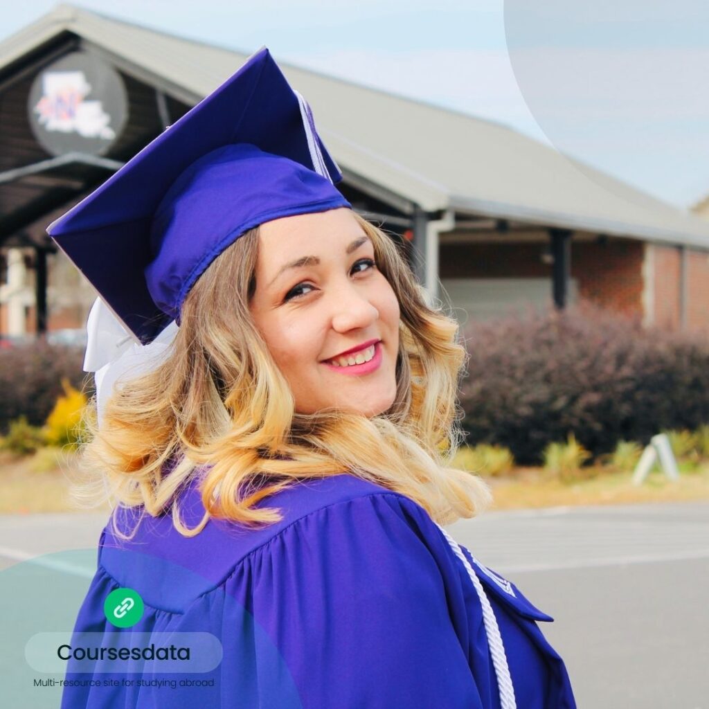 Smiling graduate in cap and gown.