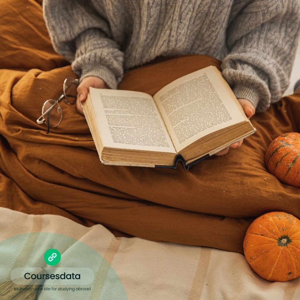 Cozy reading with pumpkins nearby.