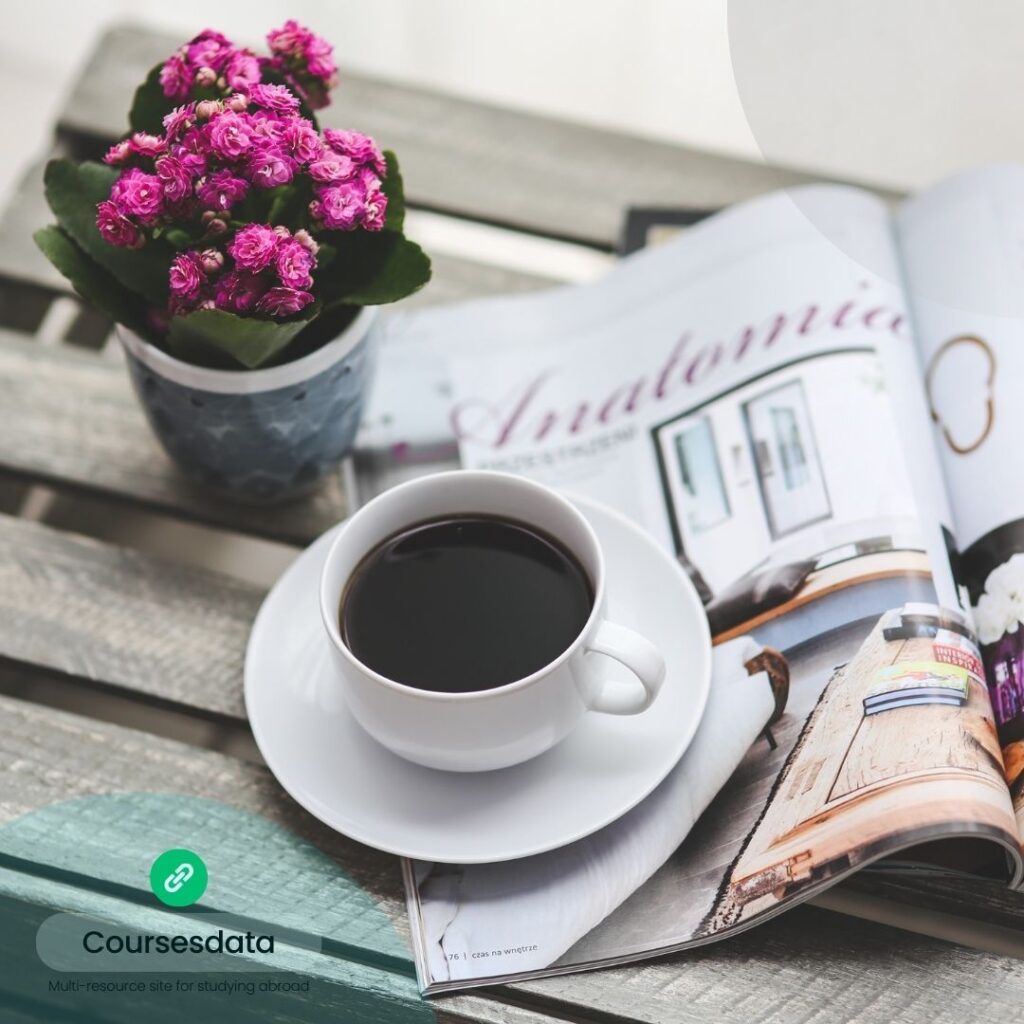 Coffee cup, magazine, potted flowers.