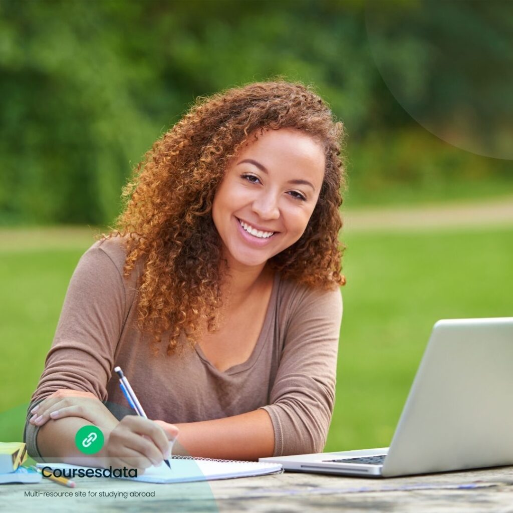 Smiling woman studying outdoors.