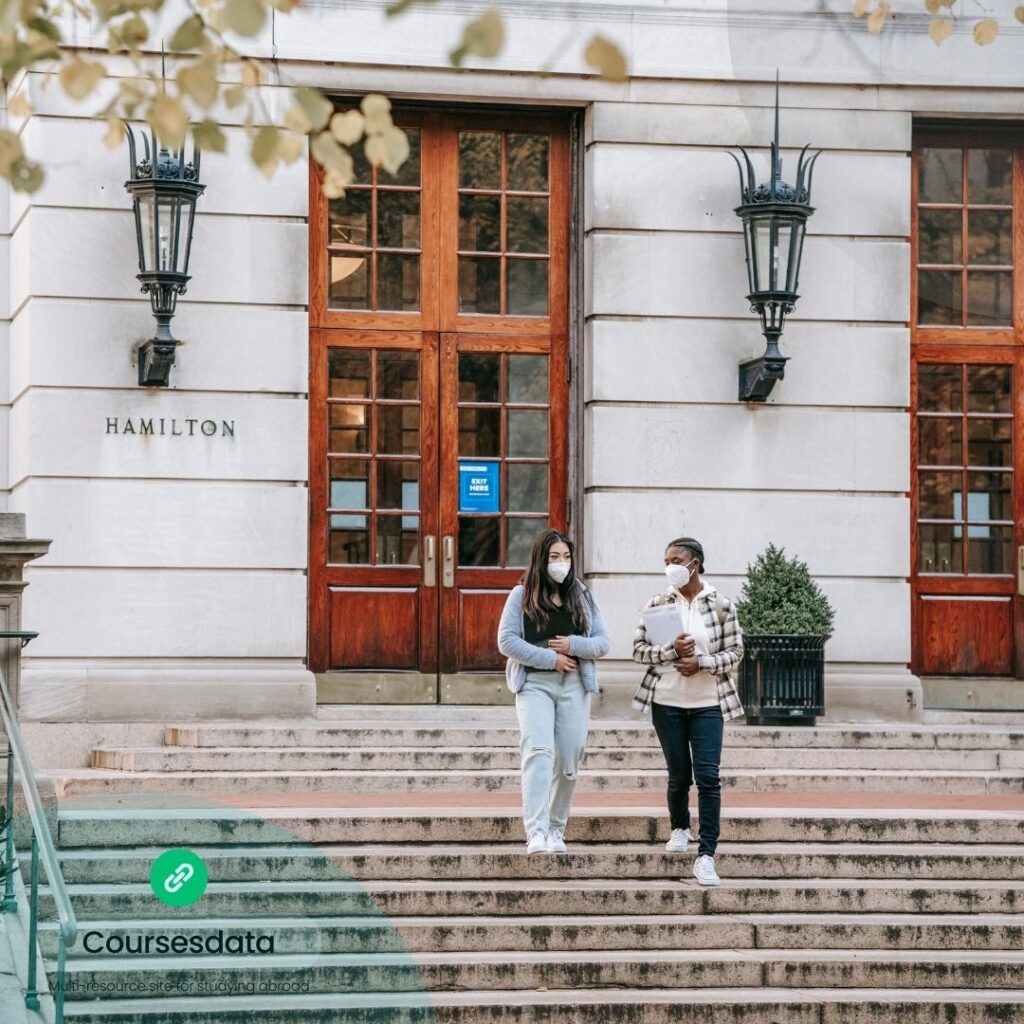 Two masked students outside Hamilton building.