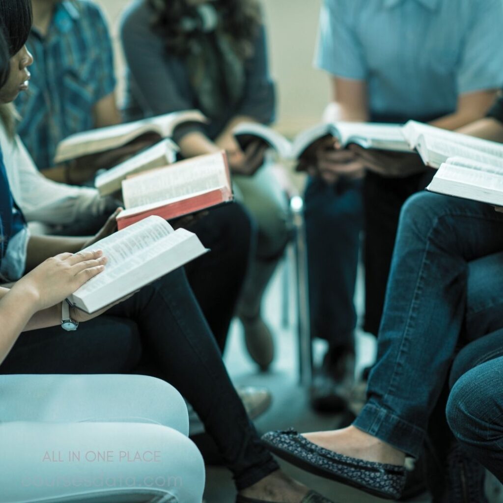 Group reading from Bibles. Seated participants in discussion. Open books in hands. Casual indoor setting. Diverse ages and attire.