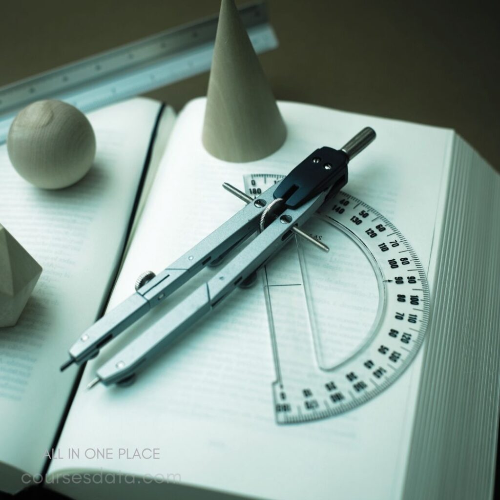 Compass on open book. Wooden geometric shapes nearby. Protractor and ruler visible. Neutral background, educational theme.