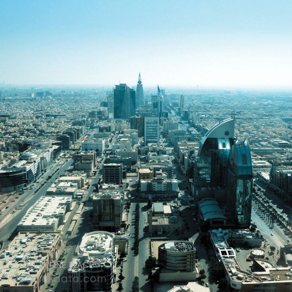 Riyadh city skyline view. Modern skyscrapers dominate landscape. Clear blue sky overhead. Urban buildings stretch into distance. Vibrant cityscape with intricate architecture.