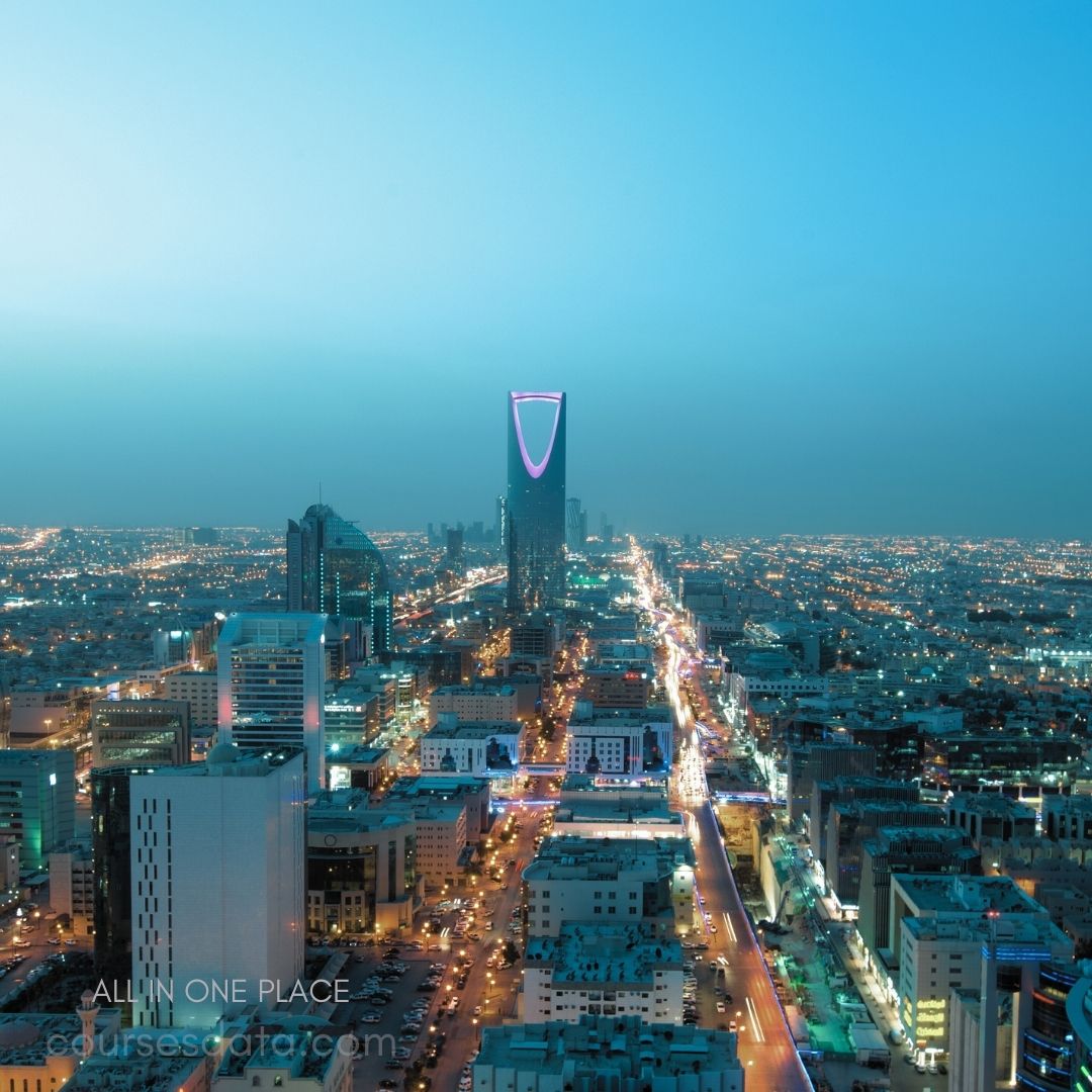 Riyadh skyline at twilight. Prominent tower illuminated purple. Streets lined with city lights. Urban landscape with modern buildings. Clear sky transitioning to night.