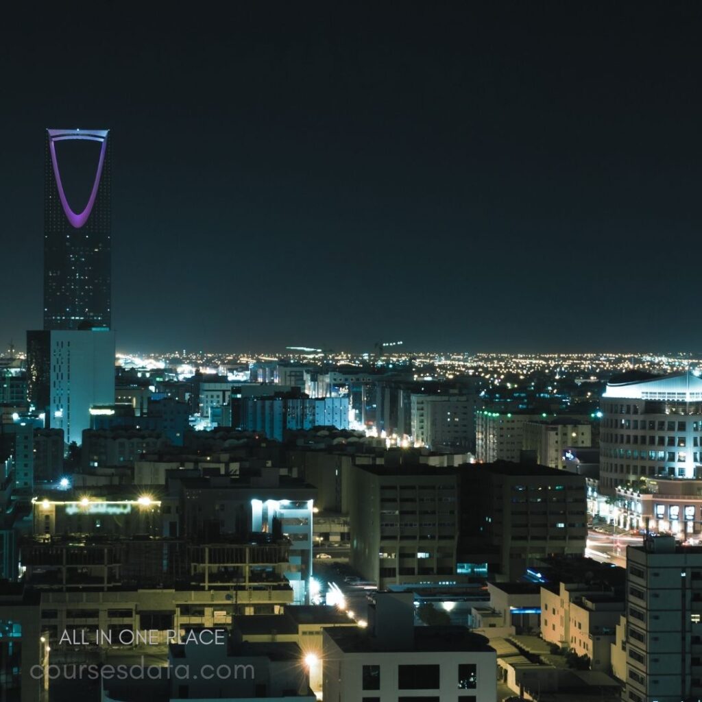 City skyline at night. Prominent tall building illuminated. Colorful lights throughout the city. Dark sky with shimmering stars. Vibrant urban landscape perspective.