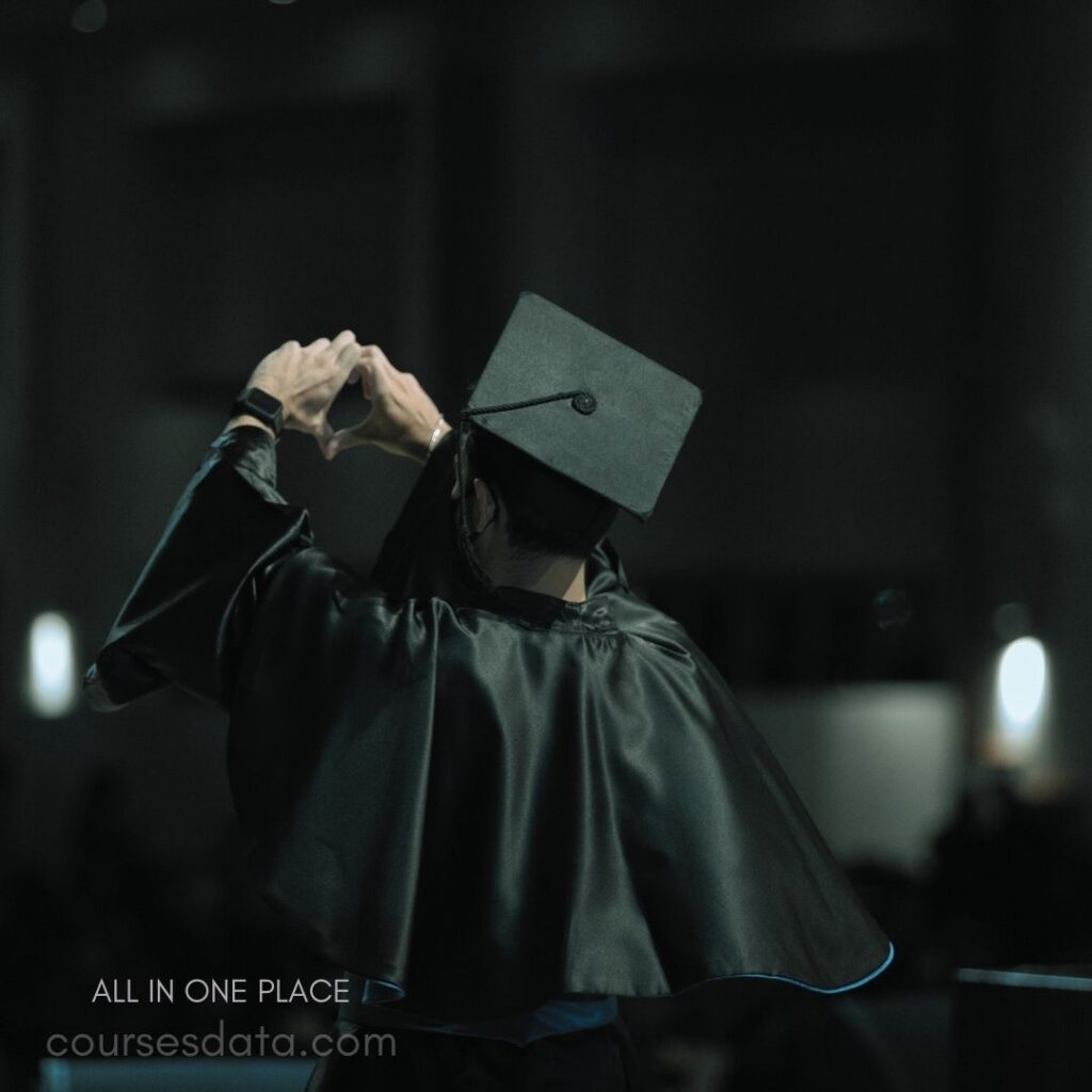 Graduating student making heart gesture.