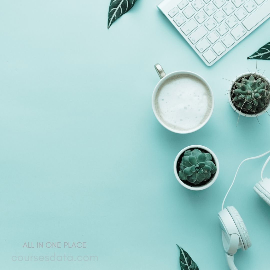 Coffee cup with foam. Two potted succulents. Headphones beside keyboard. Mint green background. Decorative leaves present.