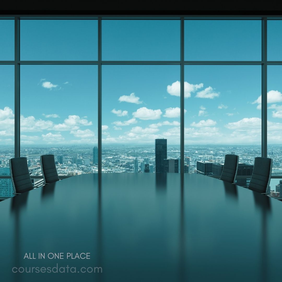 Boardroom with city view. Large conference table. Floor-to-ceiling windows. Bright blue sky. Business setting ambiance.