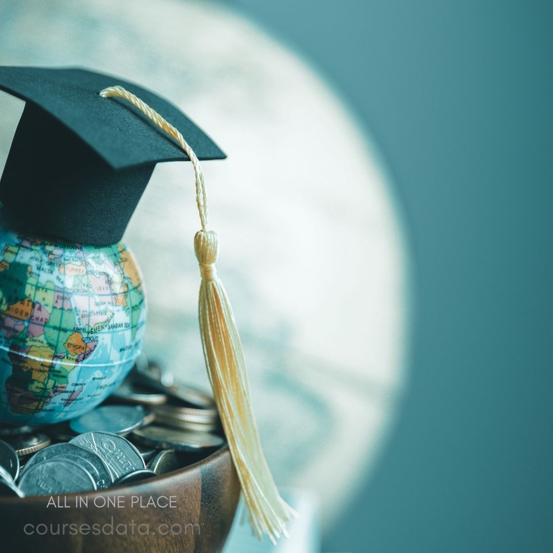 Graduation cap on globe. Coins in wooden bowl. Soft blue background. Financial education theme.
