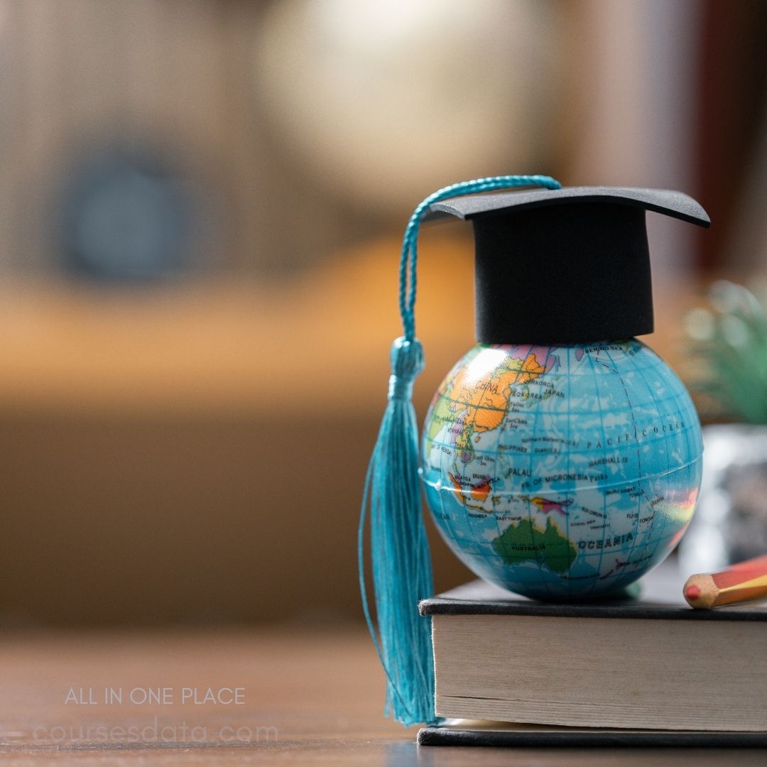 Graduation cap on globe, books.