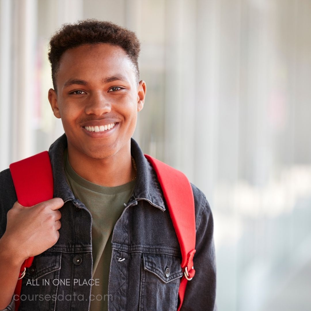 Smiling young man, red backpack. Casual denim jacket, green shirt. Bright, modern background.